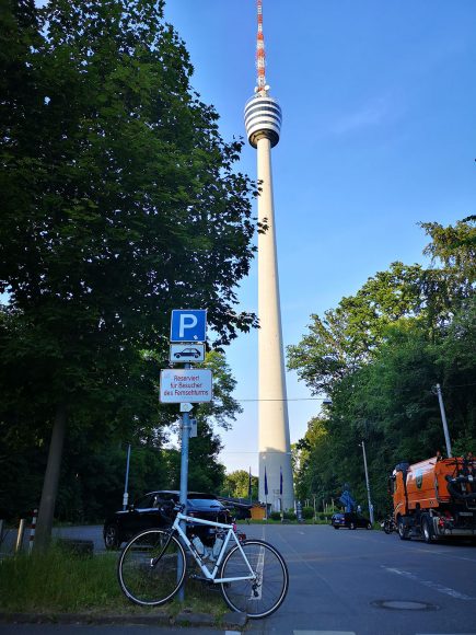 Menners stellen ihr Fahrrad vor einen Turm (Symbolbild). 
